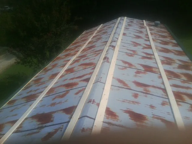 Rusted metal roof panels with new wood purlins before replacement — Storm Damage Roof Repair in Statham by Roofing Brothers