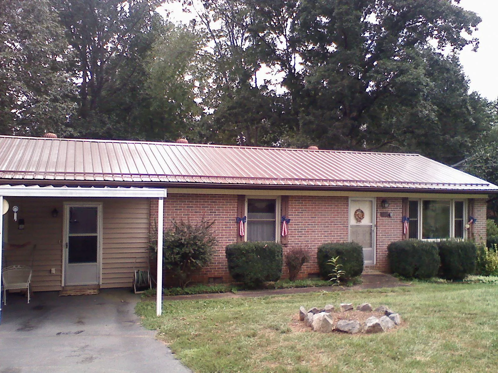 Bronze metal roof and carport on a brick ranch home — Roof Repair work by our crew in Statham